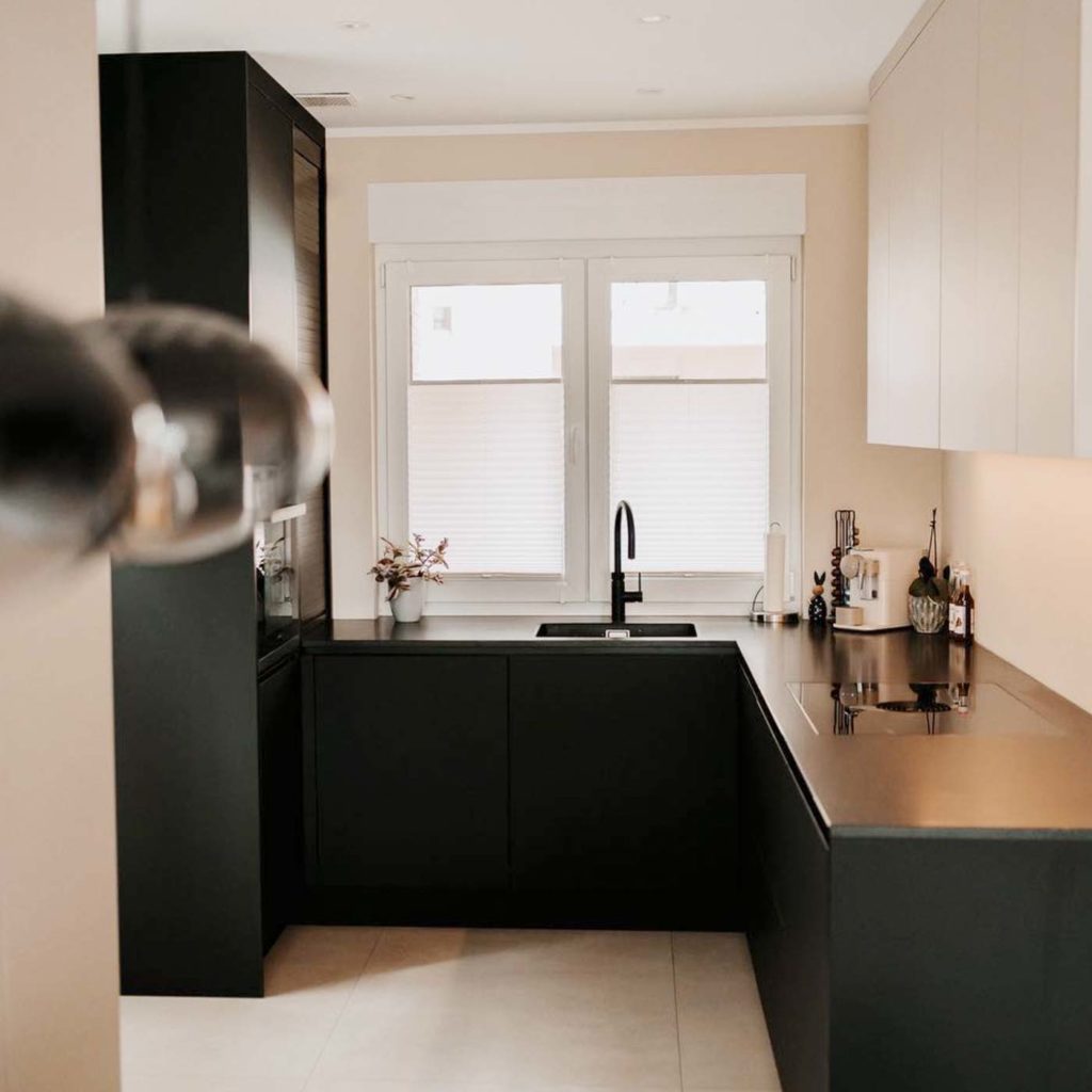 Moderne Küche mit schwarzen Schränken und Fenster